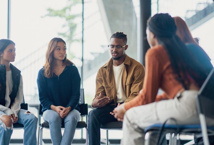 Black man in group circle discussing mental health