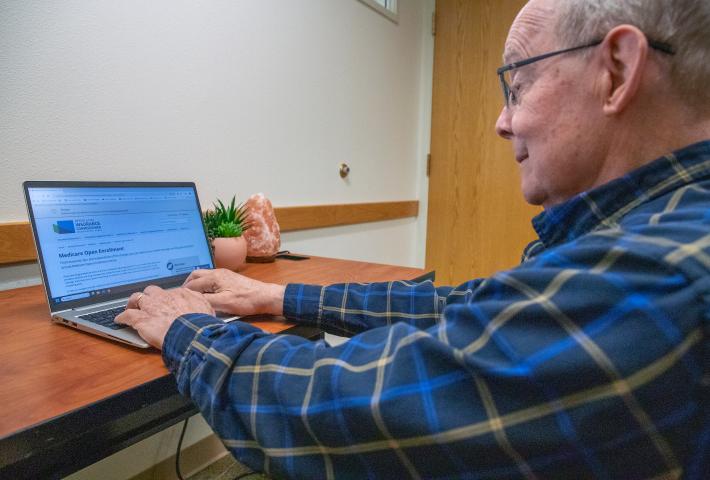 Older man looking at a webpage for Medicare open enrollment